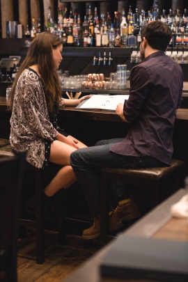 Paar sitzt in der Bar und liest Speisekarte
