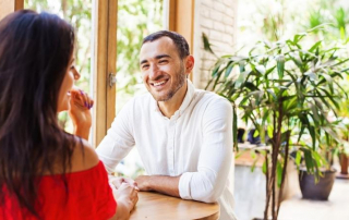 Mann lächelt Frau beim Speed-Dating an