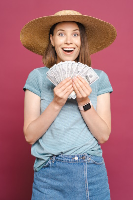 Lachende Frau mit Geldscheinen in den Händen